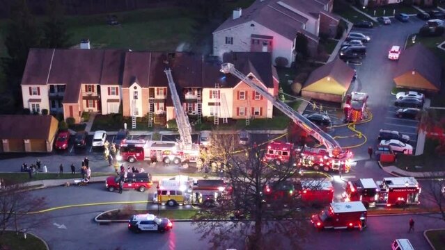 flying over a condominium house fire with firetrucks and ambulances