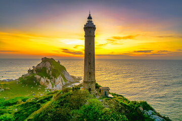 Landscape of small island with ancient lighthouse at sunrise sky is beautiful and peaceful. This is only ancient lighthouse is located on island in Vietnam