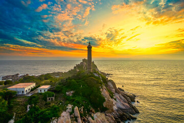Landscape of small island with ancient lighthouse at sunrise sky is beautiful and peaceful. This is only ancient lighthouse is located on island in Vietnam