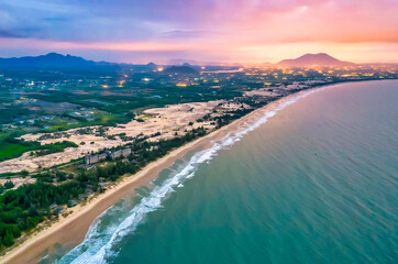 Aerial view of the central coast of Vietnam at dawn with the coast, blue sea waves, sunrise is a place for weekend relaxation and fishing of local fishermen