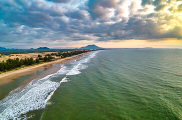 Aerial view of the central coast of Vietnam at dawn with the coast, blue sea waves, sunrise is a place for weekend relaxation and fishing of local fishermen