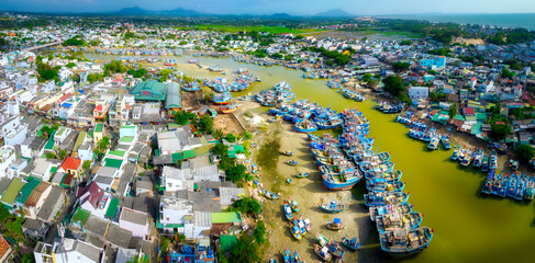 La Gi fishing village seen from above with hundreds of boats anchored along both sides of river to...