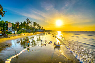 Dawn on the beach with tilted coconut trees, long sandy beach and beautiful golden sky and romantic...