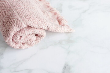 Pink towel in bathroom on marble  desk top view. Copy space. Minimal spa concept. Neutral colors.
