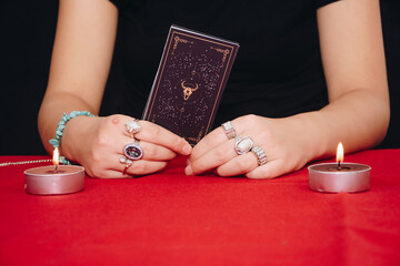 Fortune teller forecasting the future with tarot cards on black background.