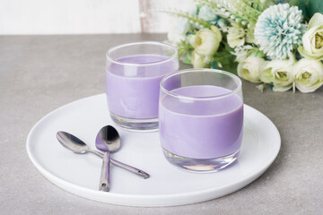 Homemade sweet taro silky pudding in a glasses cup and placed on a white plate. Healthy snacks ready to eat