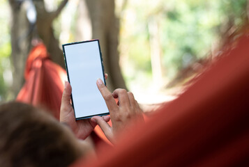 Using a smartphone while lounging in a hammock, woan
