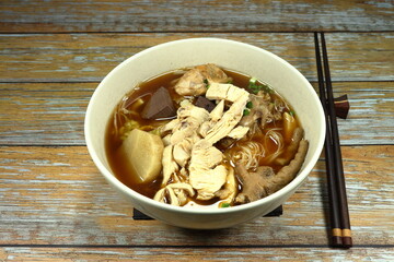 Soup of rice noodle and chicken meat serving in the bowl. Famous street food menu in Asia.