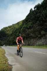 Naklejka premium A young female cyclist riding her gravel bike in the mountains.