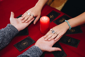 Two young friends making a Lenormand tarot session holding hand in hand.