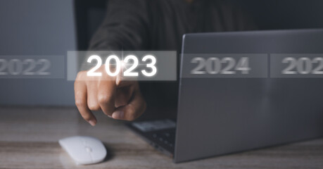 Welcome year 2023. Businessman hand pressing button New Year 2023.