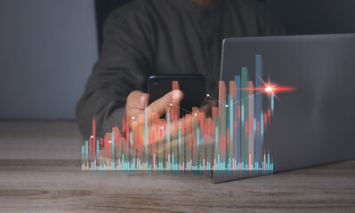 Stock market graph with man using mobile phone and computer stock trading.