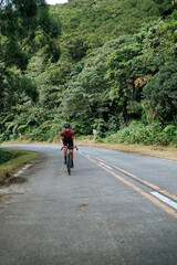Obraz premium A young female cyclist riding her gravel bike in the mountains.
