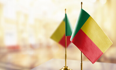 Small flags of the Benin on an abstract blurry background