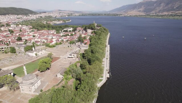 Aerial Flying Along Coastline Past Fethiye Mosque And Ich Kale Acropolis of Ioannina Beside Lake. Establishing Shot