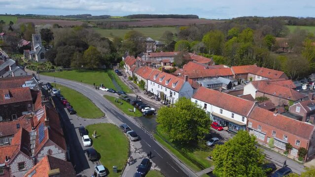 Rising Establishing Aerial Drone Shot of Beautiful Old English Village Burnham Market on Sunny and Cloudy Day in North Norfolk with Trees and Fields in Background