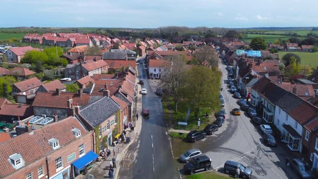 Aerial Drone Shot Flying Down Beautiful Old Burnham Market Village Main Road on Sunny and Cloudy Day in Burnham Market North Norfolk UK