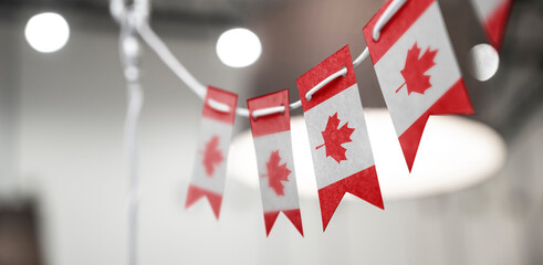 A garland of Canada national flags on an abstract blurred background