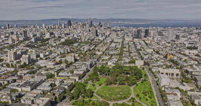 San Francisco California Aerial v169 flyover alamo square urban park capturing cityscape by the bay, tilt down birds eye view of iconic painted victorian houses - Shot with Mavic 3 Cine - June 2022