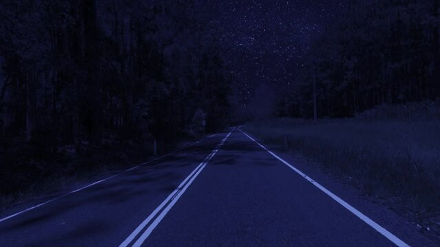 Rear facing night driving point of view POV for interior car scene green screen replacement - night footage under a clear starry sky, on quiet deserted outback roads, with brooding trees either side