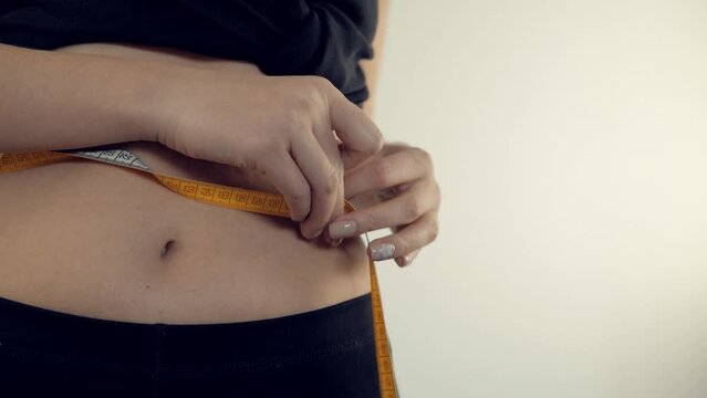 measuring waist . checking body weight . measuring tape