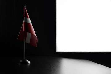 Small national flag of the Latvia on a black background