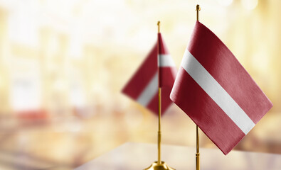 Small flags of the Latvia on an abstract blurry background