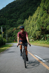 A young female cyclist riding her gravel bike in the mountains.