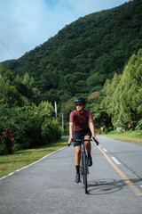 A young female cyclist riding her gravel bike in the mountains.