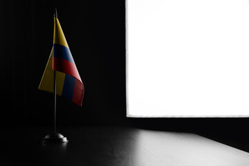 Small national flag of the Colombia on a black background