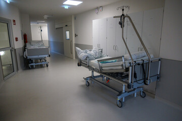 in a hospital corridor there is an empty bed