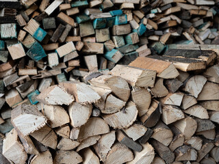 Dry firewood stacked in a pile, chopped wood for winter heating fuel of the fireplace. Natural wood background.