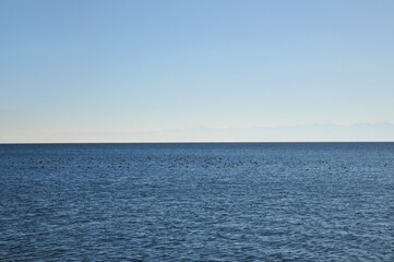 Fototapeta premium Minimal seascape horizon — calm blue ocean under clear sky. Travel promo, wellness/meditation, website header, social ads, mockups. Issyk-Kul lake, Kosh-Kul, Kyrgyzstan.