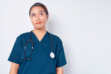 Exhausted young Asian woman nurse wearing blue uniform with a stethoscope looking tired after her...