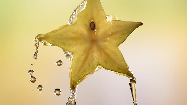 Slow Motion Macro Shot of Flowing Carambola Juice from Halved Carambola Star Fruit