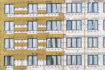 Exterior passive house wall heat insulation with mineral wool. Insulation facade of multistory residential building. Energy efficiency. Installation of external wall thermal insulation with rock wool.