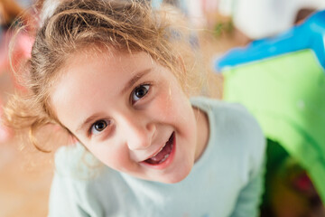 Adorable happy child smiling at camera in kindergarten