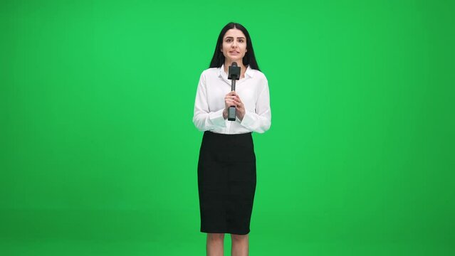 Woman reporter in suit looks into the camera and speaks into a microphone on a green background, a template for TV news agencies, journalist at work, chromakey.