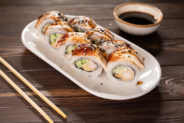 Japaneses food style. Unagi Sushi rolls on plate with chopsticks.