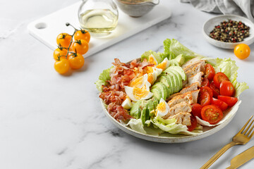 Cobb salad with bacon, avocado, tomato, grilled chicken, eggs isolated on  white background. American salad. Healthy food.