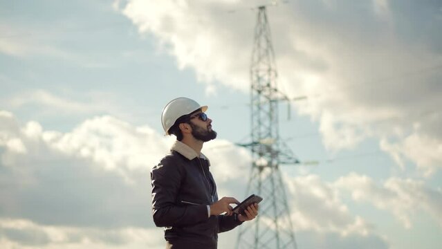 Electrical Technician Inspecting High Voltage Powerline