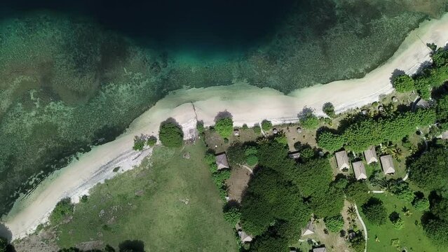 Aview from above to shore of tropical island, sandy beach, coral reef, bungalow on shore,Lombok, Indonesia, south Gili islands. Aerial view from Gili Asahan island. strip of sand on beach and blue sea