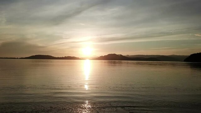Camera moves along tropical island surf strip at sunset.Bright sunrise over the sea and islands ,Lombok, Indonesia, south Gili islands.Dolly shot.