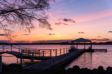 Fototapeta na wymiar purple sunset with bridge and pavilion at lake