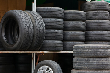 Car tires pile at the garage. Old car tires wheel on shelves shelf at wheel store workshop