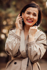 portrait of a happy attractive brunette in an autumn coat on a city street.