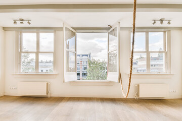 an empty room with two windows and a rope hanging from the ceiling to the floor in front of the...