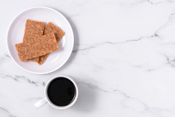 Swedish concept of balanced lifestyle-Lagom. Fuss-free. Cozy morning, minimalism composition with cup of coffee, wholegrain crispbread, on a on a marble table with copy space. Top view, flat lay.