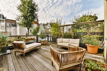 an outdoor living area with wooden furniture and potted plants on the roof deck, surrounded by blue...