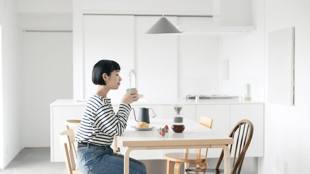 部屋でコーヒーを飲む若い女性